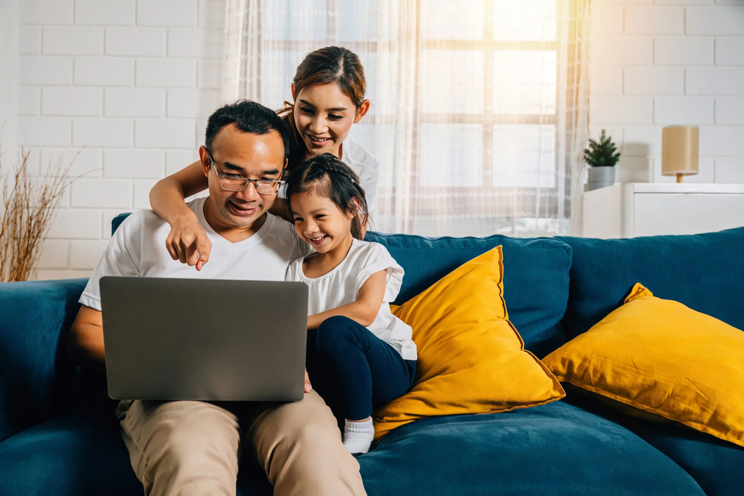 Parents and kids gathered on the couch with a laptop